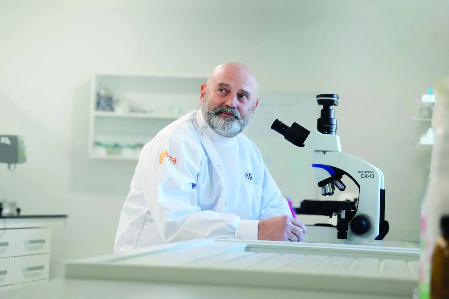 Le Dr Patrick Pageat, fondateur de l’IRSEA, à côté d’un microscope